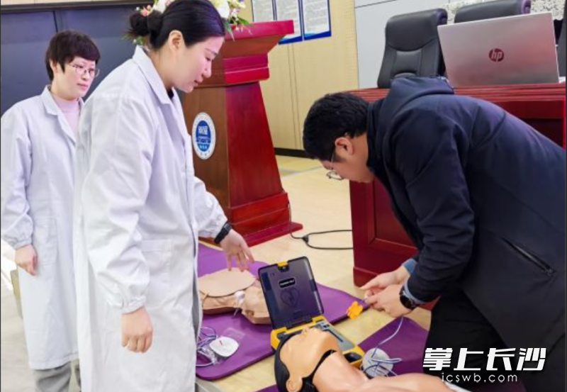 医护人员向参训者讲解心肺复苏、使用自动体外除颤仪（AED）的急救要点。