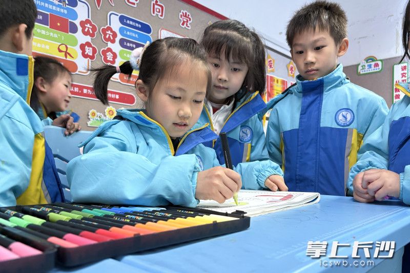 叶欣然在教室里作画，吸引同学驻足观看。 均为长沙晚报全媒体记者何文瑞摄