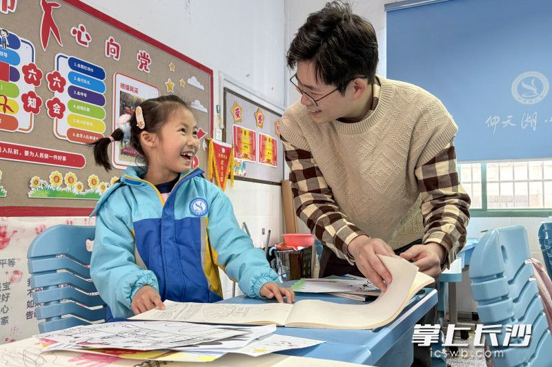 叶欣然开心地向爸爸介绍自己的画集。