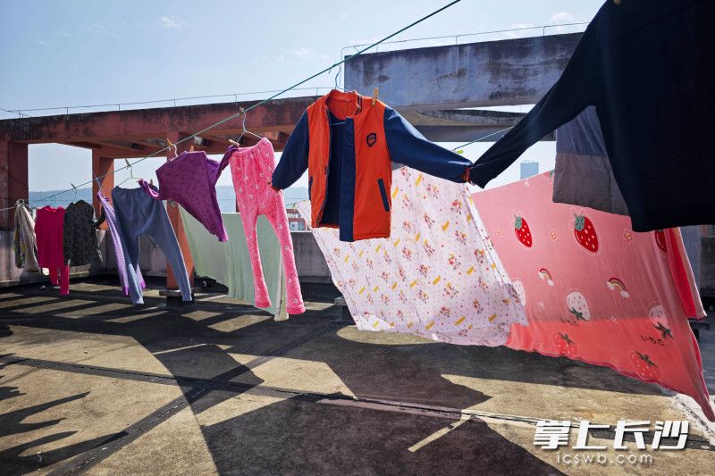 为了晒得更充足，衣服的袖子被夹在一起，好似“手牵手”。