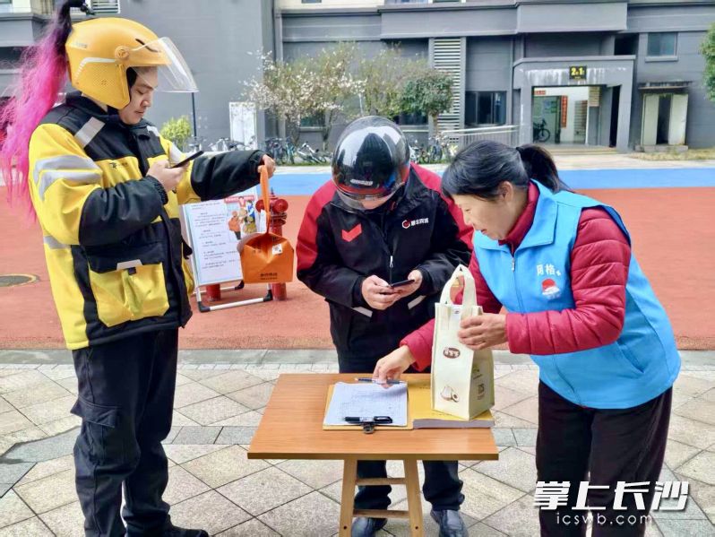 骑手将餐盒交给社区代送点，完成登记就可以轻松奔赴下一个站点。 均为长沙晚报全媒体记者李卓、通讯员王岚摄
