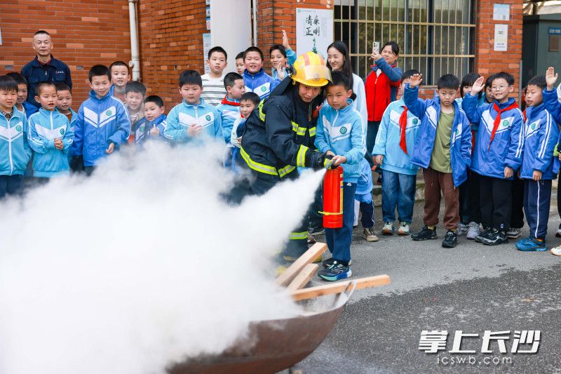 消防员在指导孩子们进行灭火实操。 长沙晚报通讯员 邹志鹏 摄