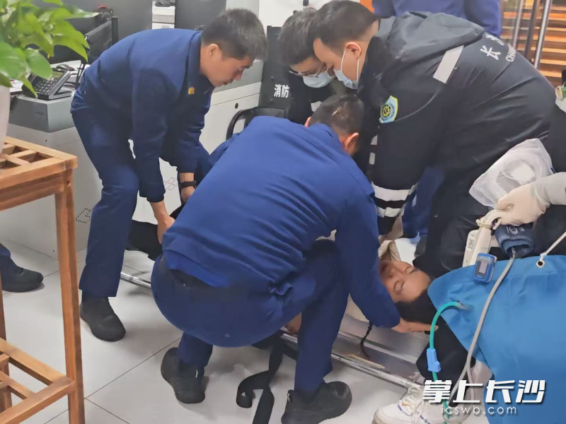 消防员正在救助晕倒女子。  长沙晚报通讯员 余娜娜 供图