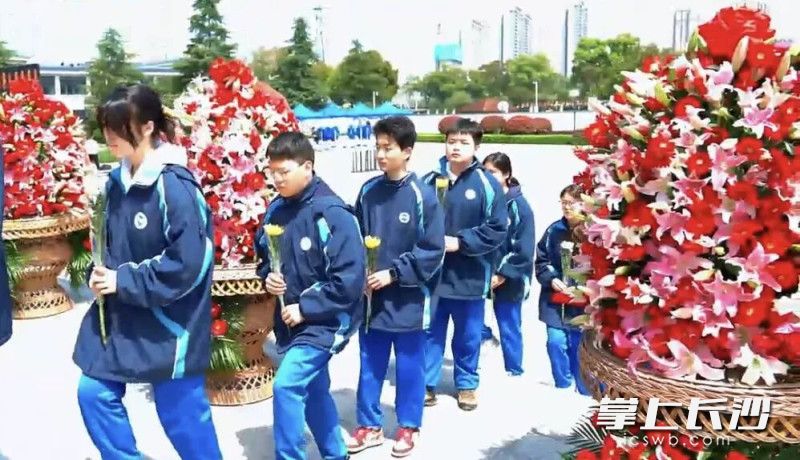 雅礼书院中学学生们手持鲜花，依次缓步绕行纪念碑，向英烈敬献鲜花。均为通讯员 苏珊 供图