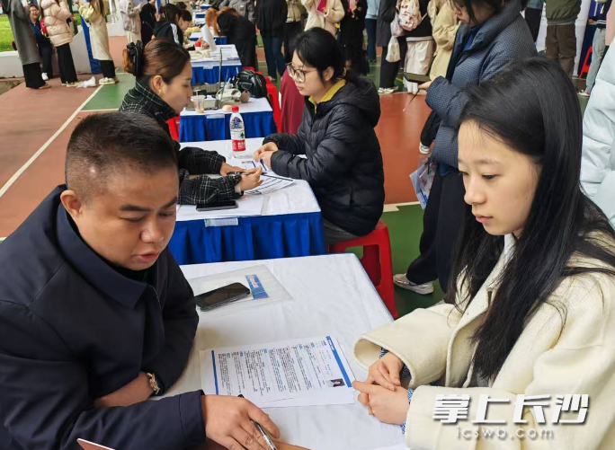 湖南女子学院的学生面对面咨询企业。