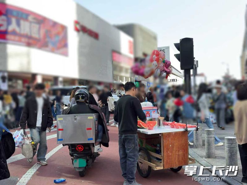 人行道旁变摊位，行人绕路难行。