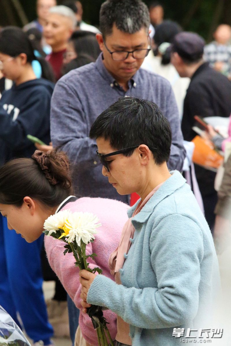 周女士手捧菊花祭扫英灵。