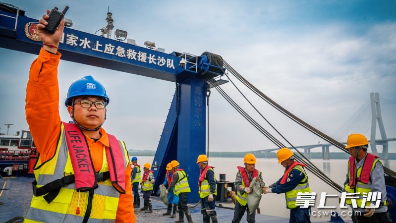 中国应急“长沙号”多功能救援船将沙袋制好搬到水上，每分钟可灌装25～30 袋，1小时产量抵30人作业。