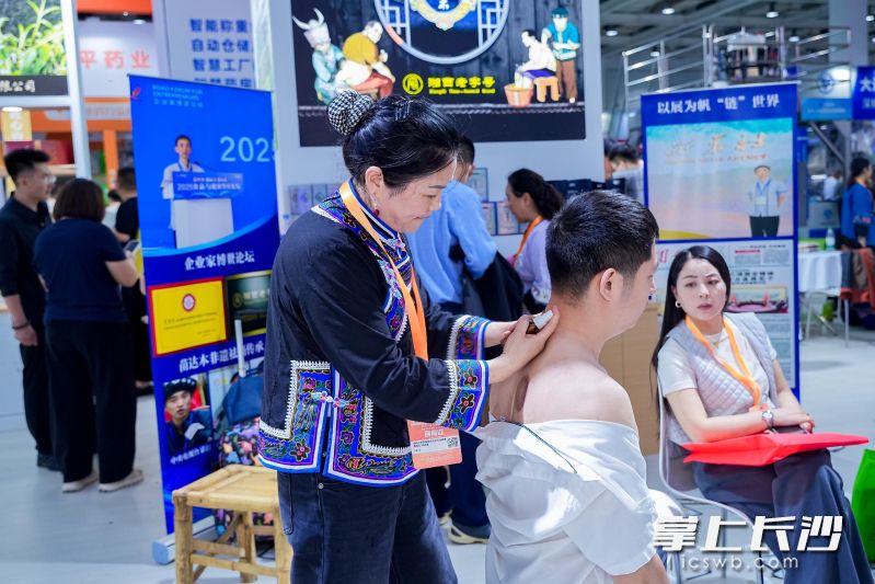 参展观众体验湘西非遗祛痛疗法。