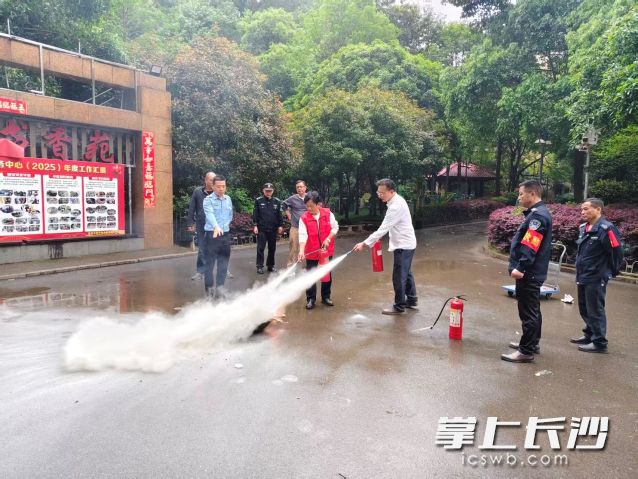 大家轮流上前对着模拟火点实操使用灭火器灭火。
