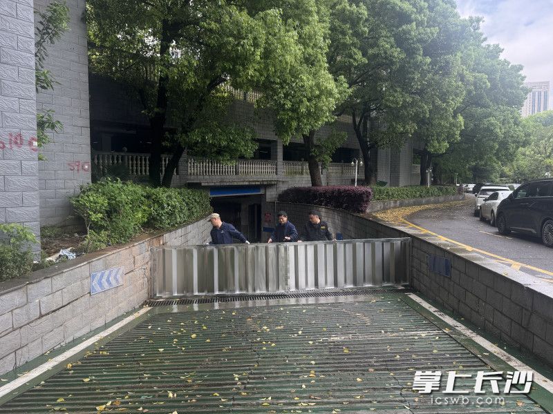 华雅花园地下车库入口处物业工作人员在检查挡水板。 均为全媒体记者 周游 摄