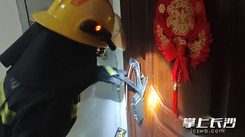 消防员正在破拆开门。 长沙晚报通讯员 王磊 摄