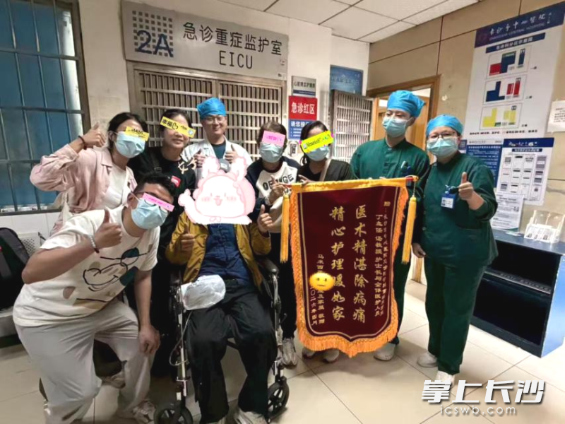 外籍患者出院前，家属给医护人员送来锦旗并合影留念。