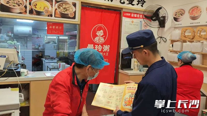 图为消防宣传员在商铺进行安全知识宣讲。 长沙晚报通讯员 董文文 摄