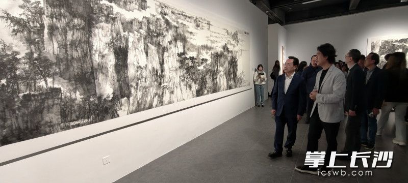 观众驻足欣赏大幅画作。