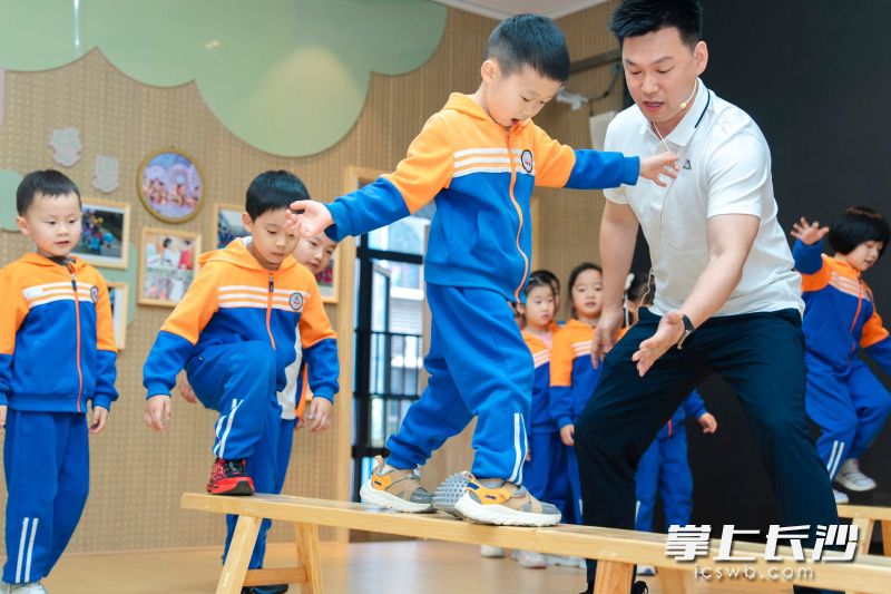 大班体育活动示范课上，田源老师指导孩子们玩“闯关”游戏。