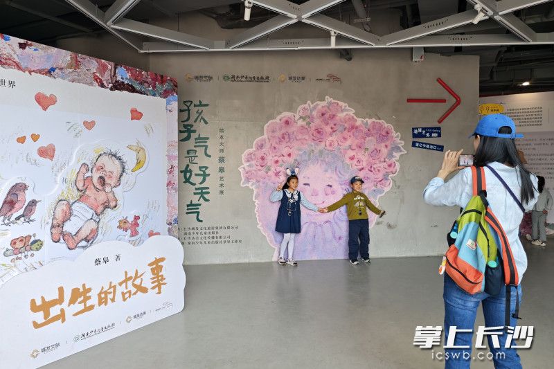 市民带着孩子在“孩子气是好天气——绘本大师蔡皋艺术展”前打卡留影。均为长沙晚报全媒体记者 郭雨滴 摄