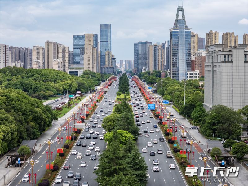 岳麓大道沿线路灯杆上整齐悬挂五星红旗，道路沿线花坛繁花盛放、错落有致，景致格外靓丽。均为长沙晚报全媒体记者 郭雨滴 摄