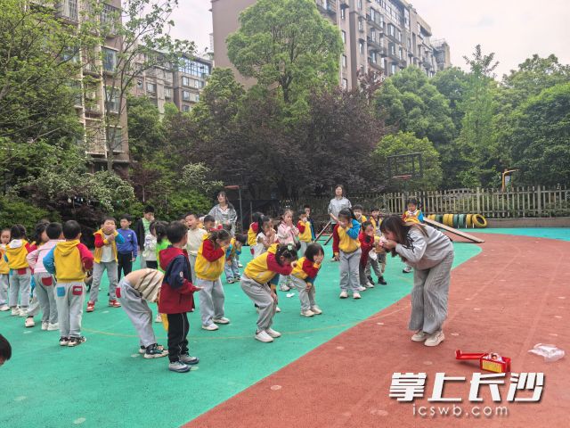 园区安全负责人教导孩子弯腰低姿快速前行逃生要领。