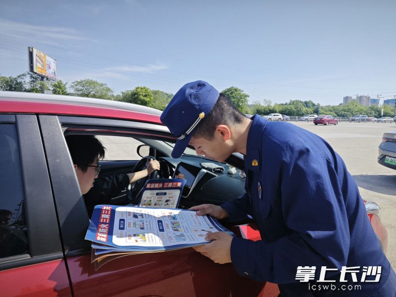 消防宣传员向驾乘人员发放防火资料。