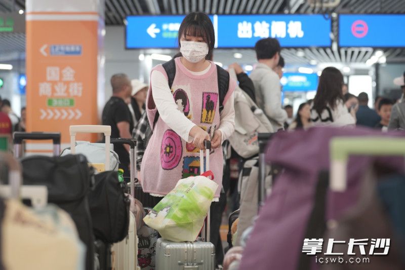 游客在“行李丛”中寻找位置安置行李。