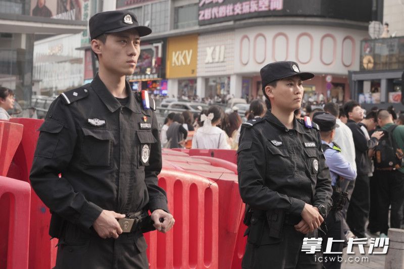 在人流量巨大的五一广场十字路口，两位特警正在聚精会神着注视着来往的行人车辆。