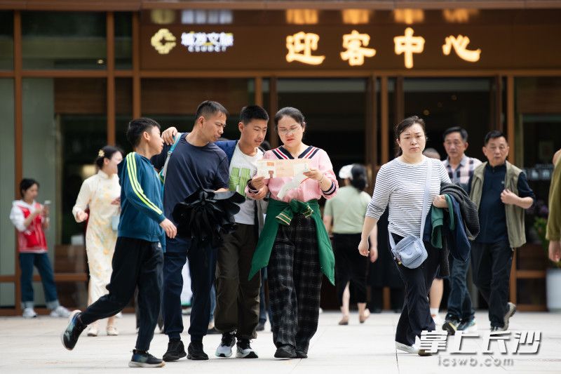 游客们从融合广场悠闲走出。