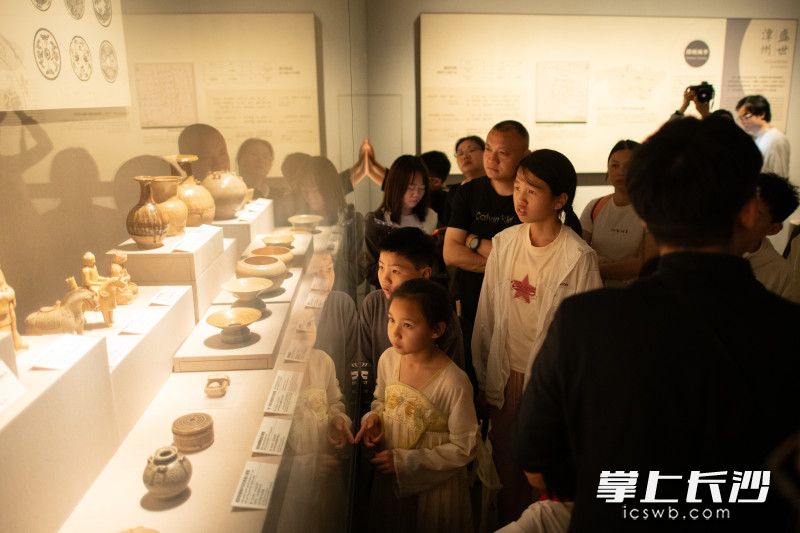 游客们在公益讲解志愿者讲解下观展。