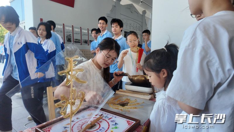 校本选修课程展示区，糖画体验吸引参观者。