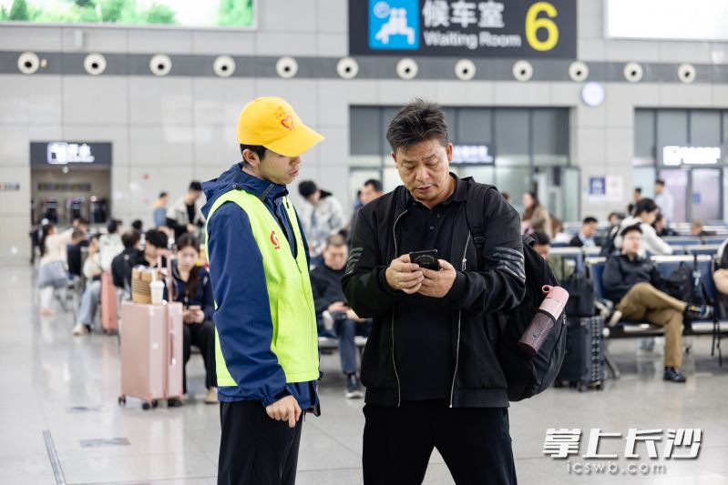 志愿者为乘客提供引导咨询。