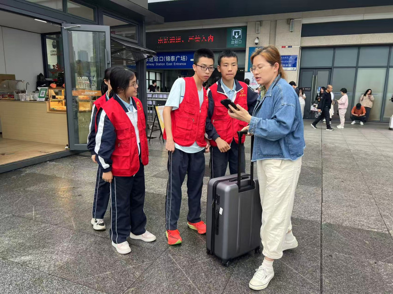 在锦泰广场，青年志愿者正在为游客指路。