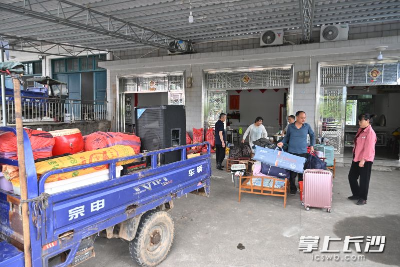 孔秋成正在清理生活用品，运至集中安置点。