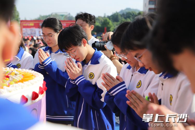 在点生日蜡烛环节,每班一名代表共同点燃十八岁生日蜡烛,全体学生闭上双眼默默许愿。 在点生日蜡烛环节,每班一名代表共同点燃十八岁生日蜡烛,全体学生闭上双眼默默许愿。