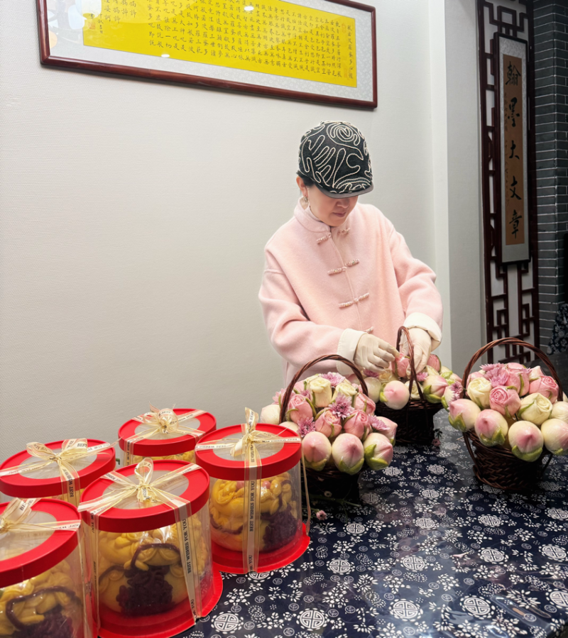 待打包的馒头花束整齐摆放，麦香四溢；食品架上，玫瑰、牡丹馒头静待封装，即将送往千家万户。