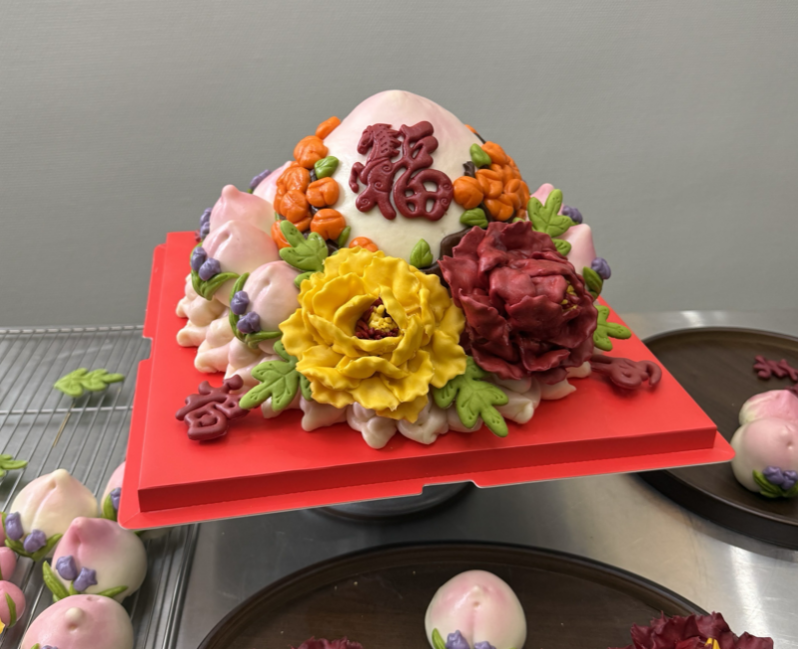 牡丹玫瑰寿桃拼搭花篮，花型饱满、寓意美好，备受青睐。