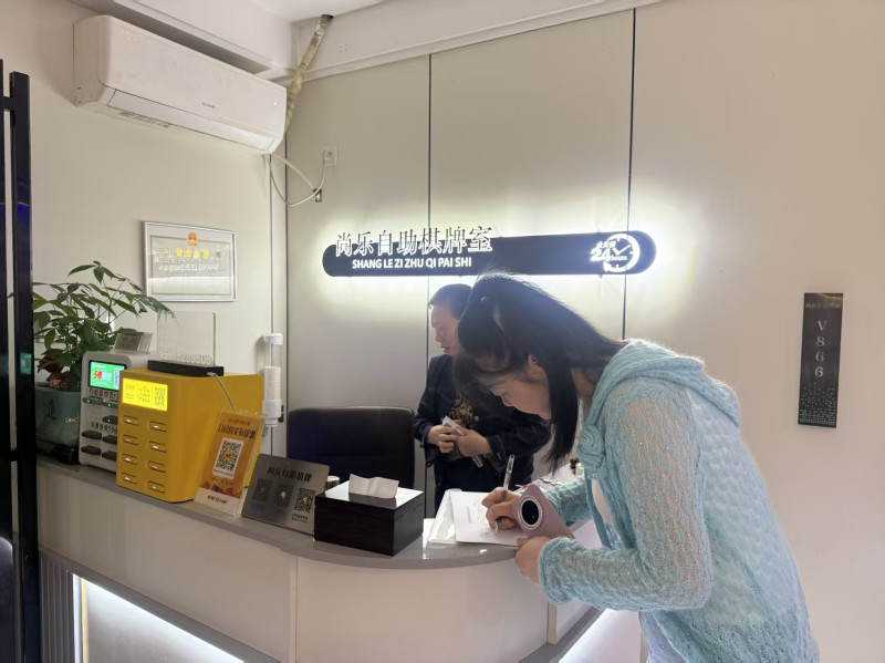 网格员正在查看辖区棋牌室经营状况。