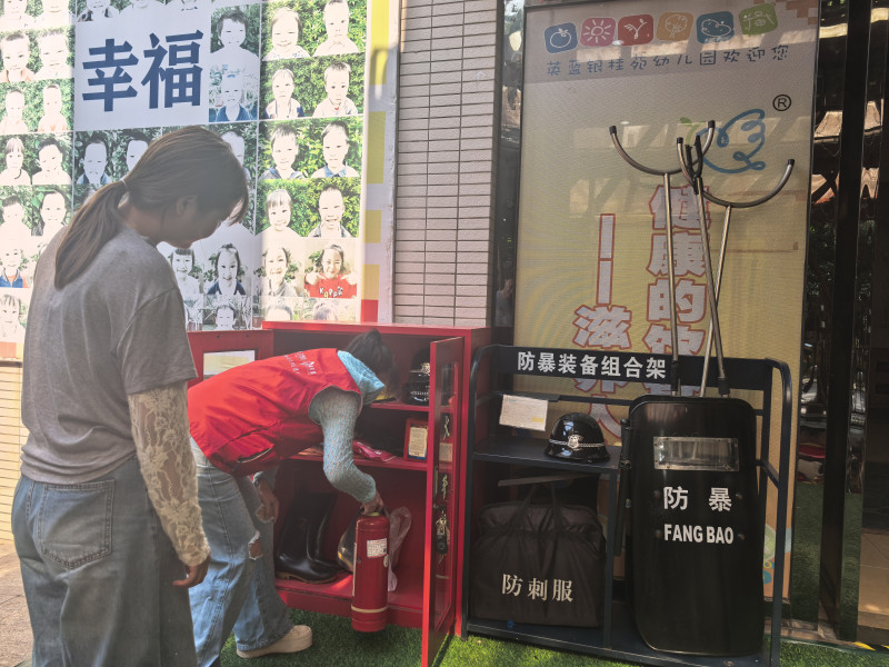 志愿者正在查看辖区幼儿园消防器材是否完好有效。
