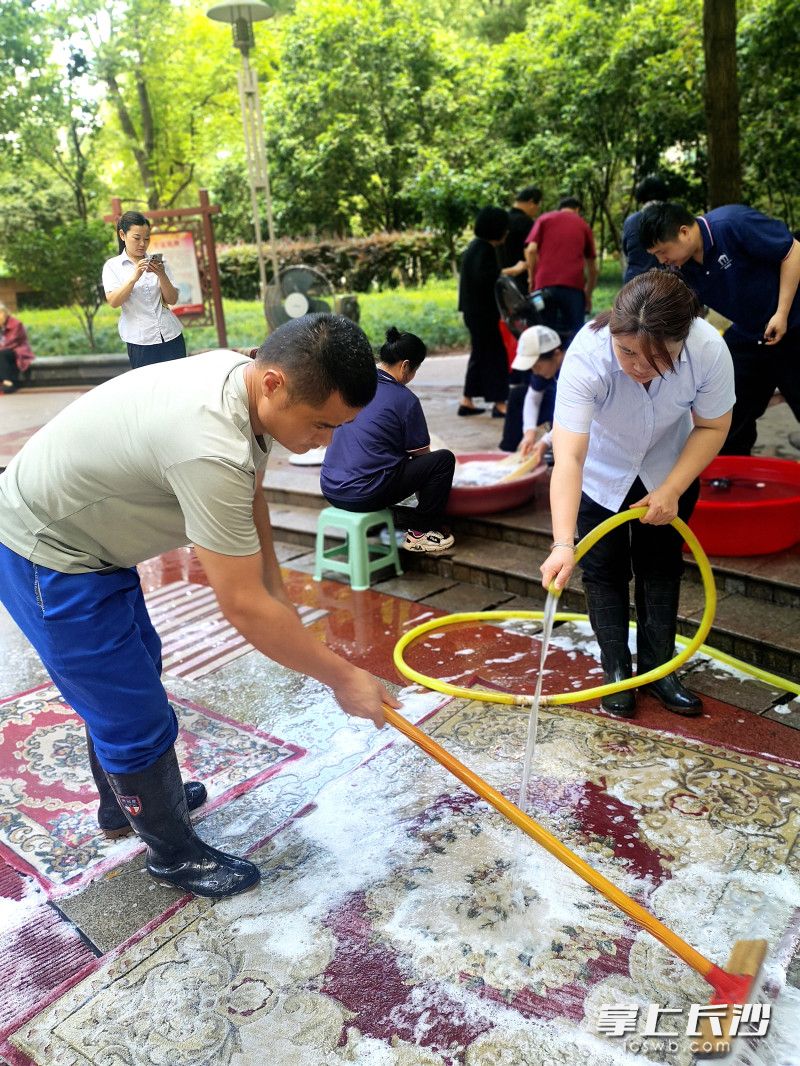 物业员工志愿者在为业主清洗地毯。均为长沙晚报全媒体记者 贺文兵 摄
