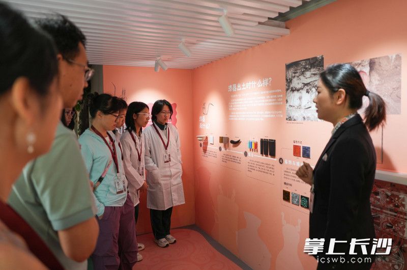 狸猫学宫・文物医院以马王堆漆器保护为核心，图为博物馆教育员向学生讲解马王堆汉墓漆器的由来。
