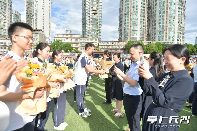 老师们掏出手机，记录下学生们献花的这一刻。