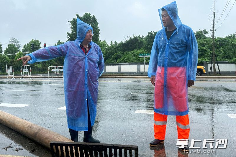 长沙市城区防涝排渍抢险队长陈欣（右）与队员商讨排涝方法。