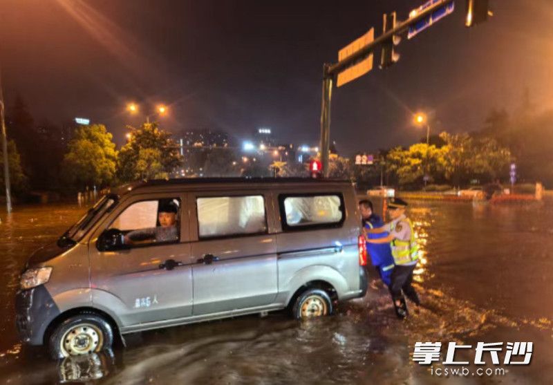 长沙县行政执法局执法人员紧急救助雨中抛锚车辆。长沙县行政执法局供图