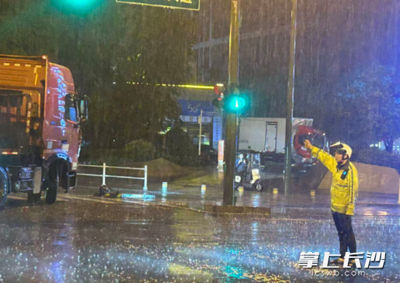 长沙县公安局交管大队警员冒雨值守，指挥过往车辆。长沙县公安局供图