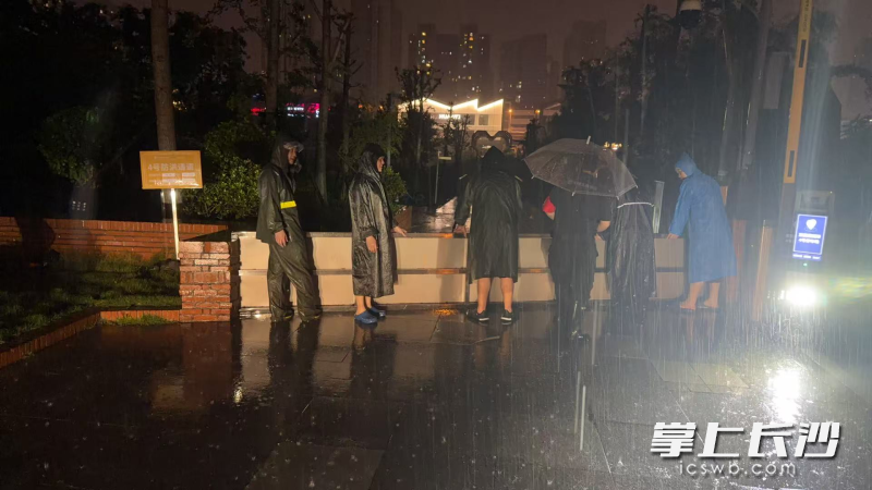 雨花区工作人员冒雨对溪悦荟防洪通道搭建防洪挡板、沙袋。