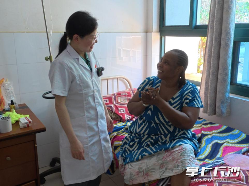 中塞友好医院的病房里，术后恢复良好的 Mariama Bundu（右）面带幸福的微笑坐在床沿，双手紧握，向专程来查房的宋玉莹医生（左）表达最深切的感激。跨越语言的相视一笑，见证着深厚的情谊。