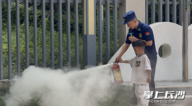手把手教导幼儿灭火实操。