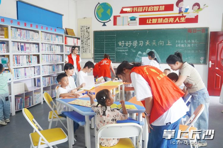 在平安巧绘趣味闯关游戏中，大学生志愿者指导孩子尽情创作。