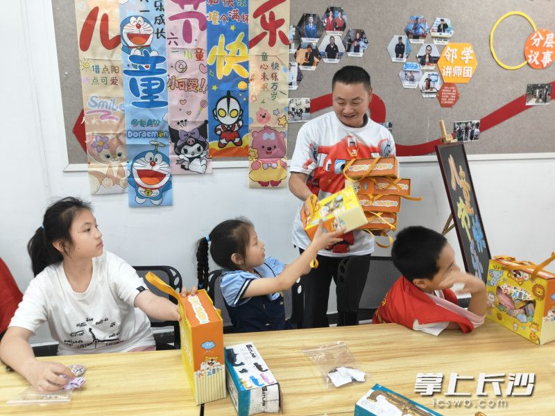 平日里穿梭街巷的快递外卖小哥，化身孩子们心中的“超级飞侠”，为小朋友送上节日礼品。均为通讯员 谭乐 摄