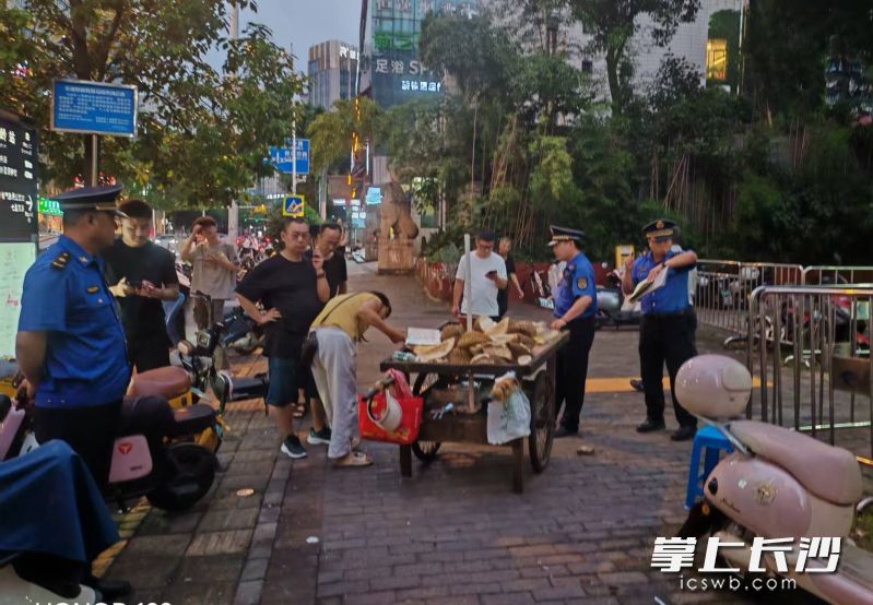 城管执法队员在疏导流动摊贩。