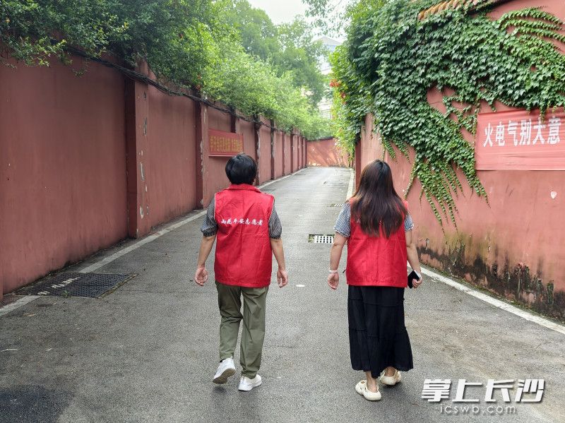 社区工作人员逐户走访沿街商铺、小区住户。